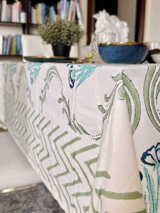 Tablecloth with green and white pattern on a table in a room with books and decor.
