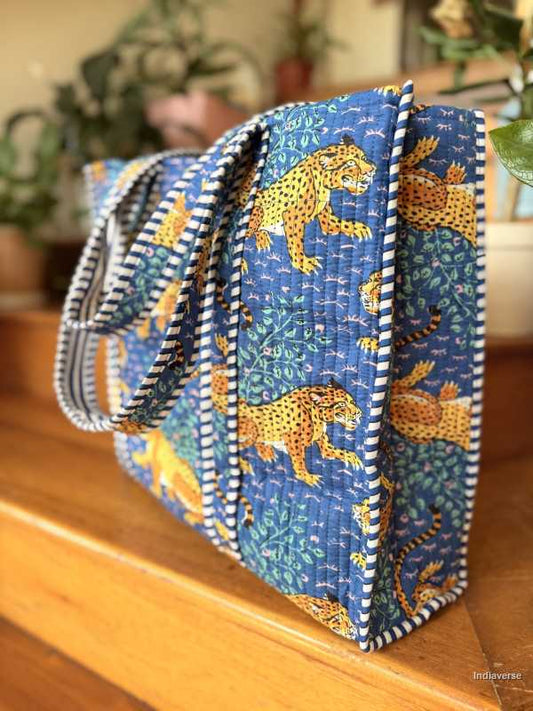 Blue fabric bags with tiger patterns on a wooden surface