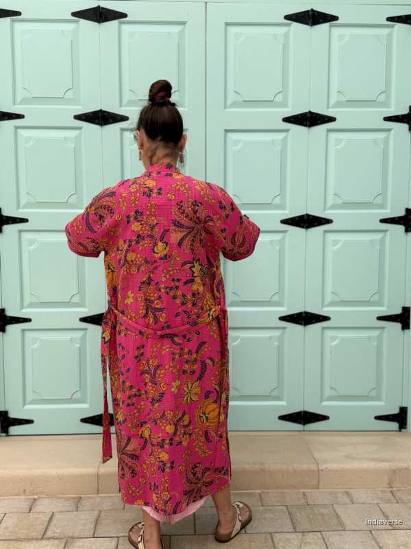 Model wearing a hot pink waffle cotton bathrobe with a relaxed fit, tie belt, and pockets, showcasing the lightweight and breathable fabric.