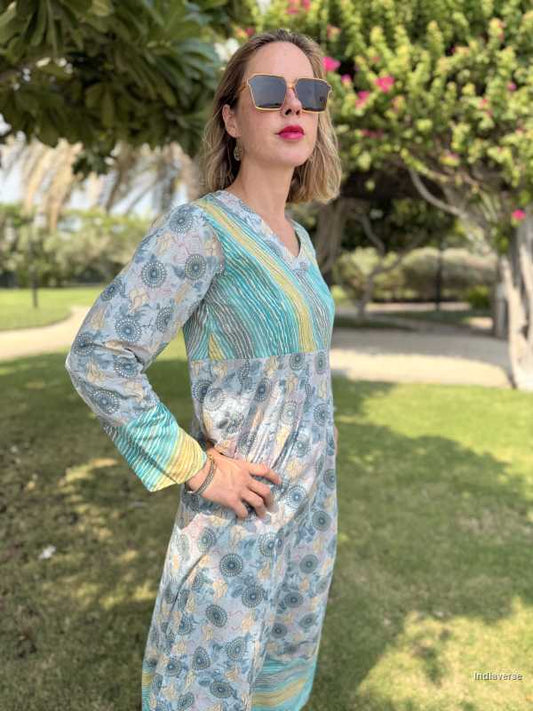Woman in a floral dress standing outdoors with greenery in the background