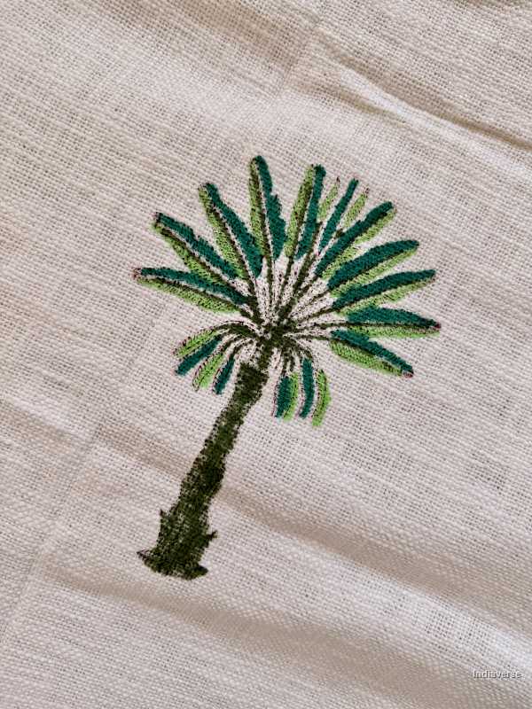 Embroidered palm tree design on a beige fabric background