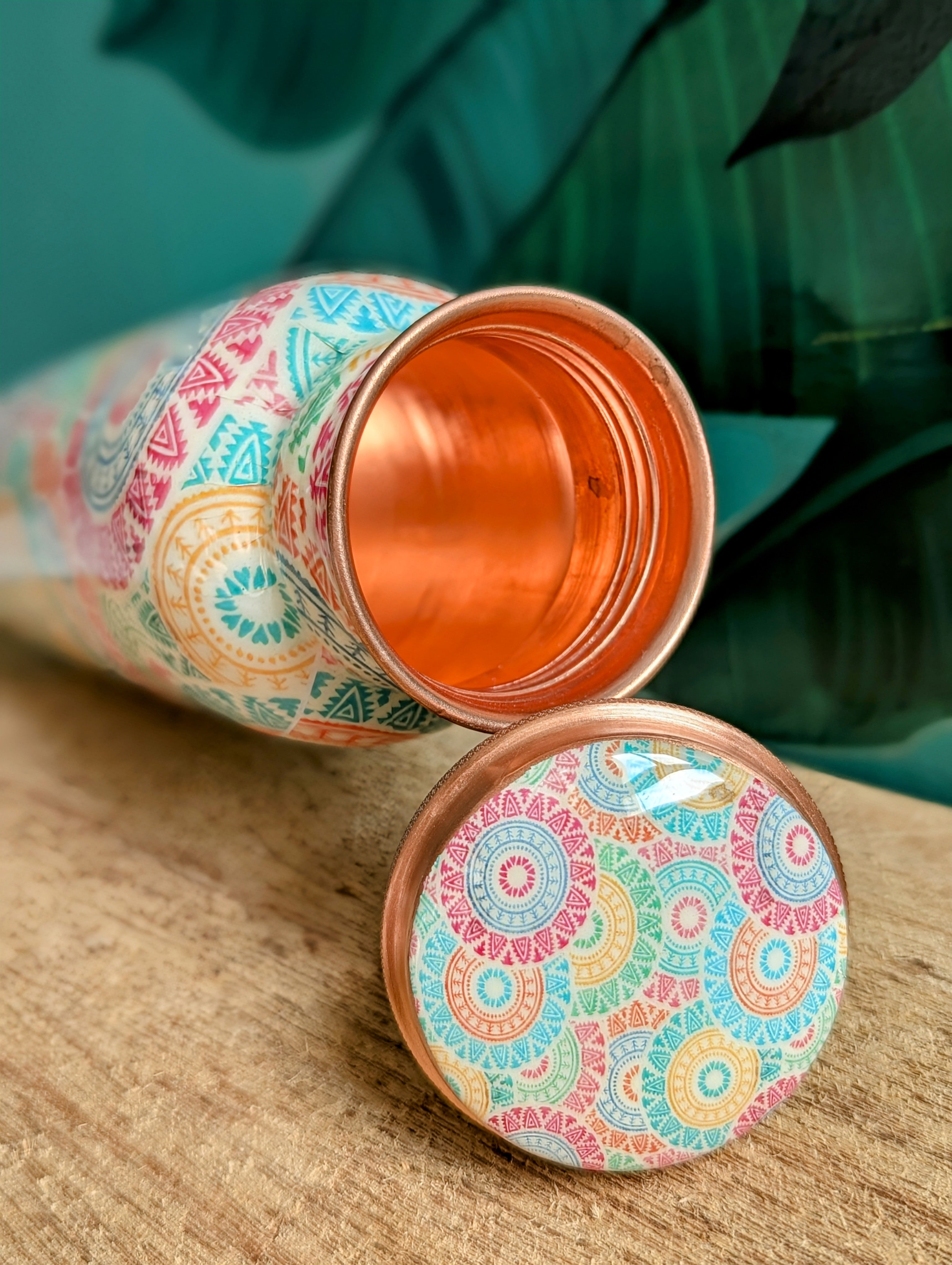 Colorful enameled Copper Bottle lying on its lid to show the copper inside of the bottle
