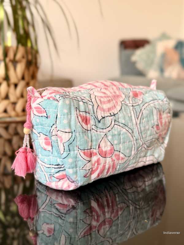 baby blue toiletry bag with pink lotus flowers sitting in a glass table in the living room | Aqua Lotus