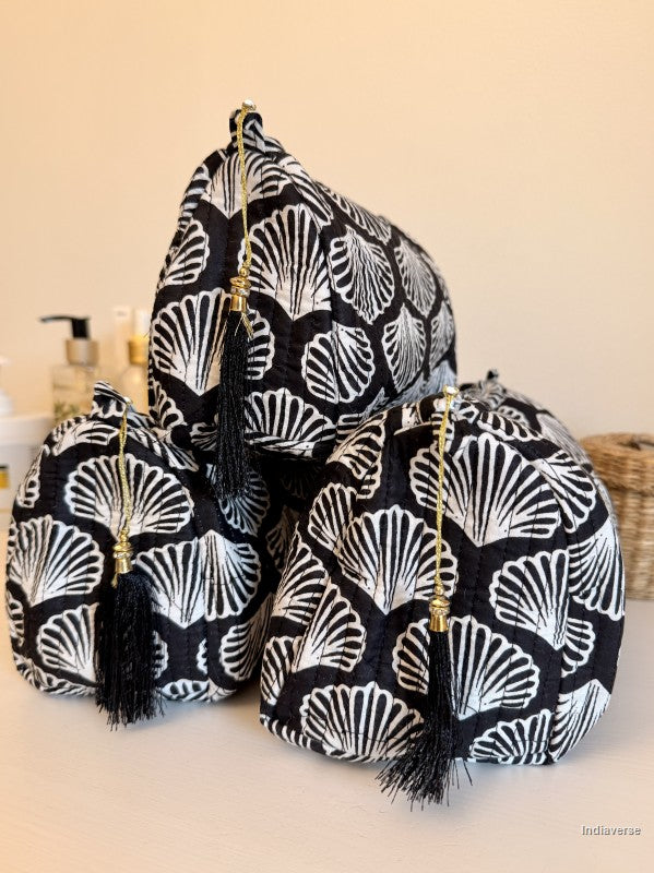 Three black and white gingham drawstring pouches with black tassels and gold zipper pulls, arranged on a light surface against a beige background | Black Sea Shell