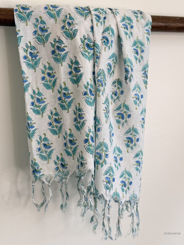 Cotton scarf with small blue flowers hanging on a wooden beam