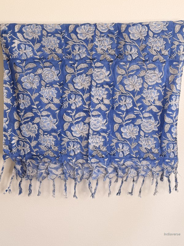 Blue cotton scarf with white floral design hanging from a wooden beam