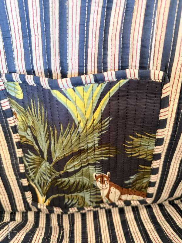 Close-up of a striped fabric with a tropical patch featuring a leopard.