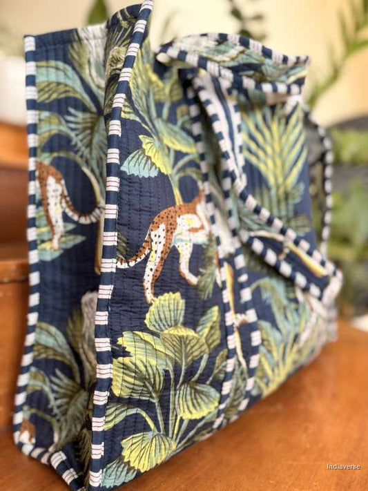 Fabric basket with jungle-themed design featuring leopards and foliage on a wooden surface.