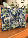 Tropical patterned bag with leopards and plants on a wooden surface