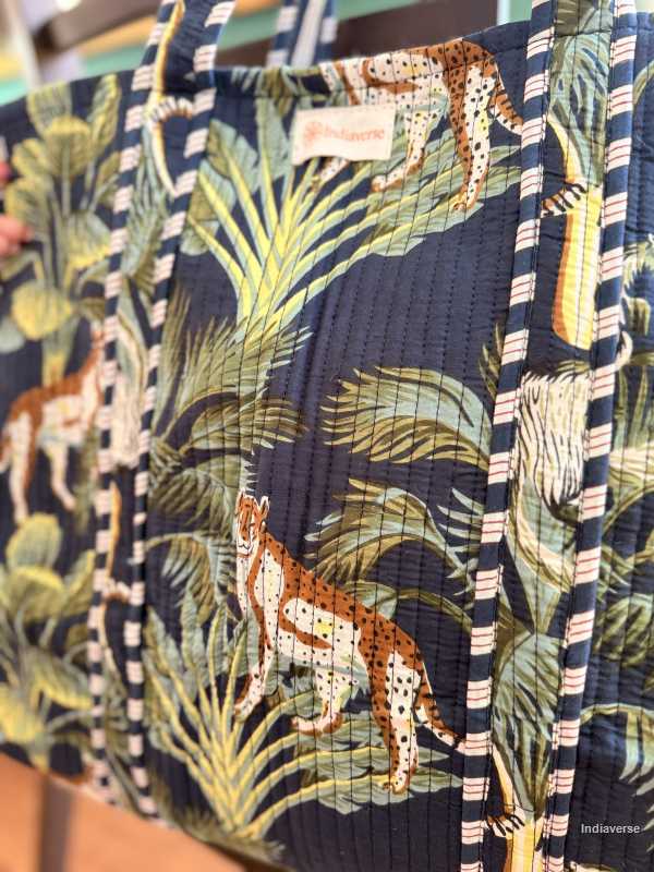 Tote bag with jungle animal and leaf pattern on a blue background