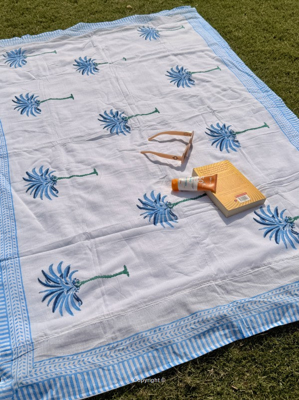 White fabric with blue floral patterns on a grassy background