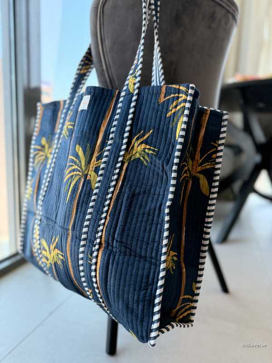 Blue tote bag with palm tree design on a chair indoors