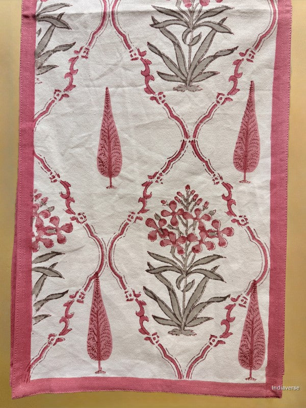 A square textile piece, likely a table runner or decorative cloth, featuring a pink and gray botanical block-print pattern on an off-white background, finished with a solid pink border.
