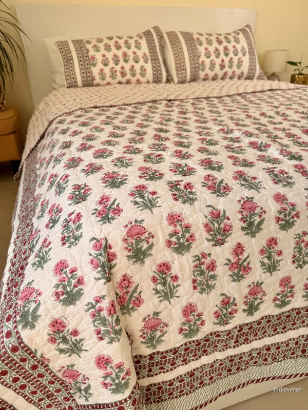Cotton comforter with red floral design neatly arranged with matching pillow cases in a queen size bed