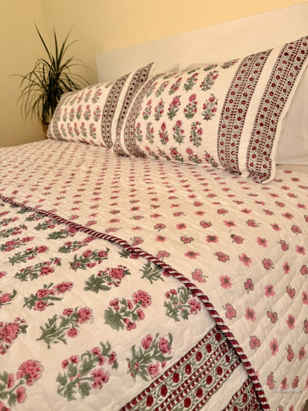 Cotton comforter with red floral design neatly arranged with matching pillow cases in a queen size bed