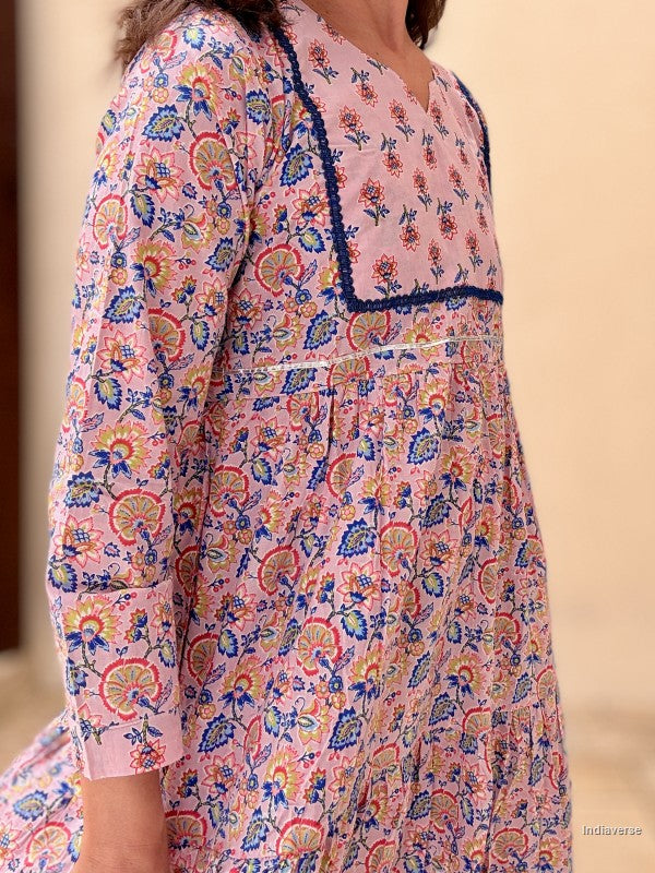 Close-up of a person wearing a colorful floral dress with a neutral background