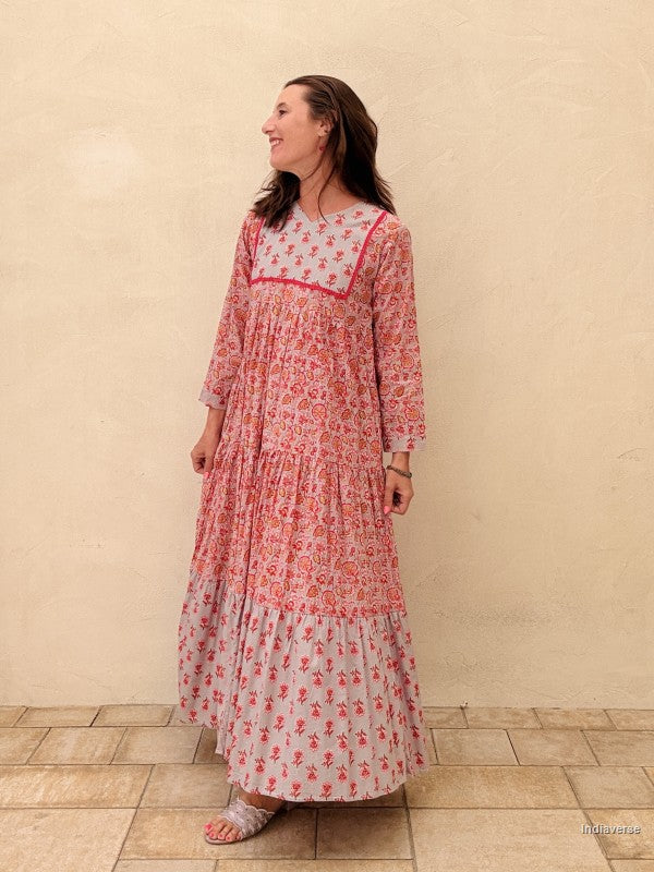 Woman wearing a long, floral dress with a white background
