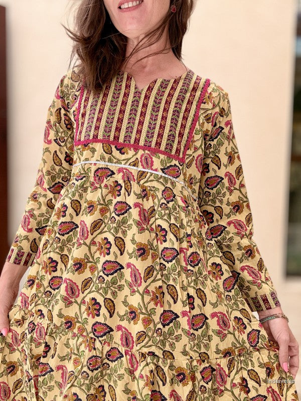 Woman wearing a patterned dress with a neutral background