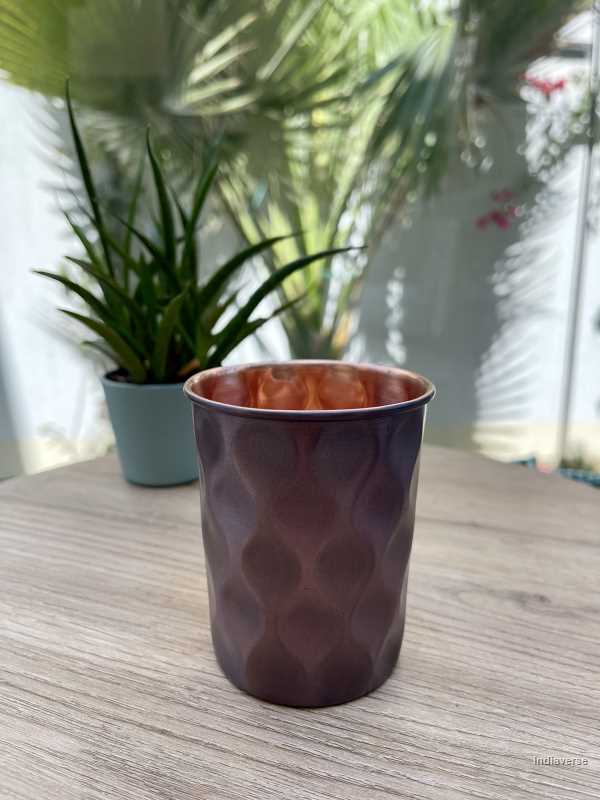 polished copper cup with hammered diamond shape details made for serving water and healthy alternative to glass