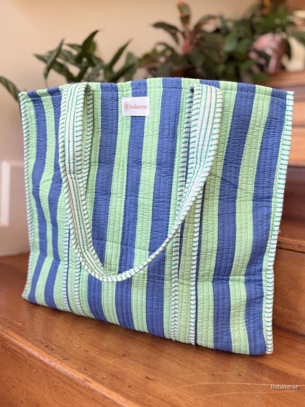 Striped bag with blue and green pattern on a wooden surface