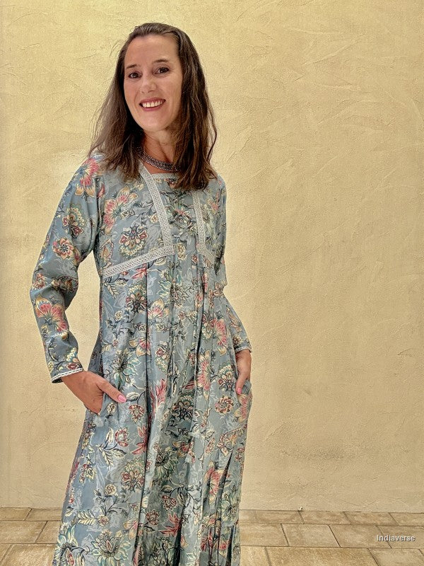 Woman wearing a floral dress against a beige wall.