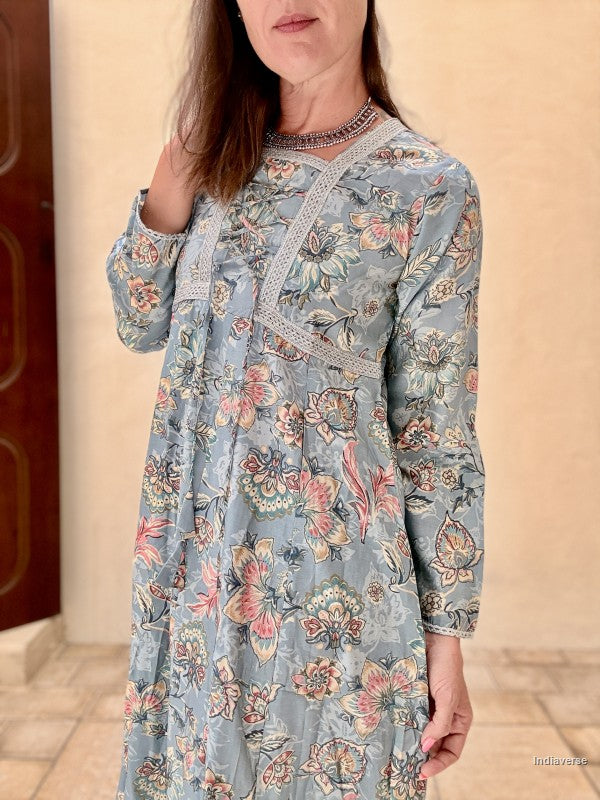 Woman wearing a floral patterned dress with a neutral background