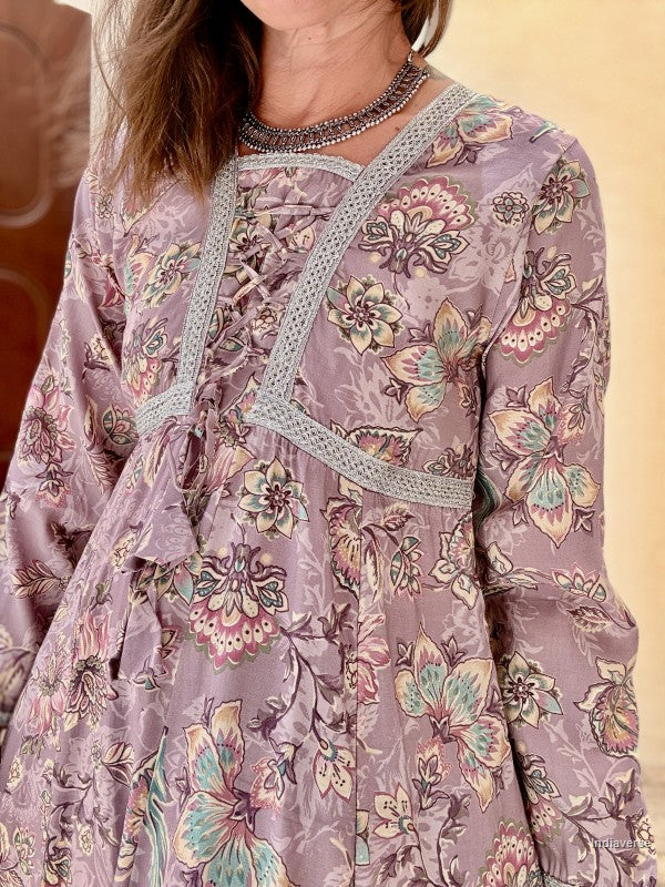 Close-up of a person wearing a floral patterned dress with intricate details.