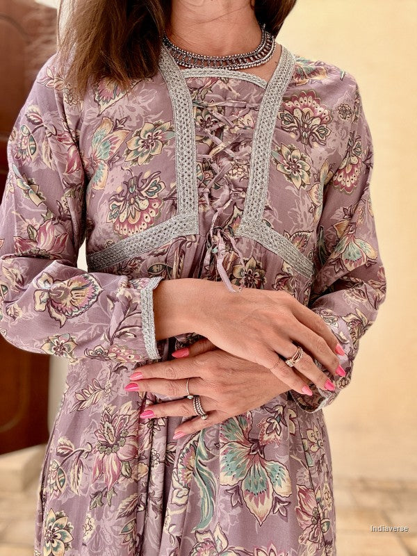 Woman wearing a floral patterned dress with intricate details on a beige background