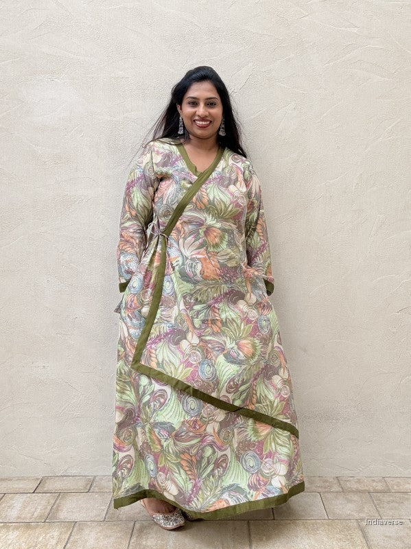 woman wearing a long maxi dress with green floral design that is tied up on the side