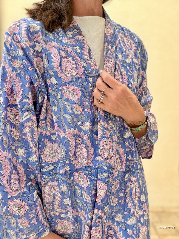 Person wearing a blue floral patterned shirt against a beige background