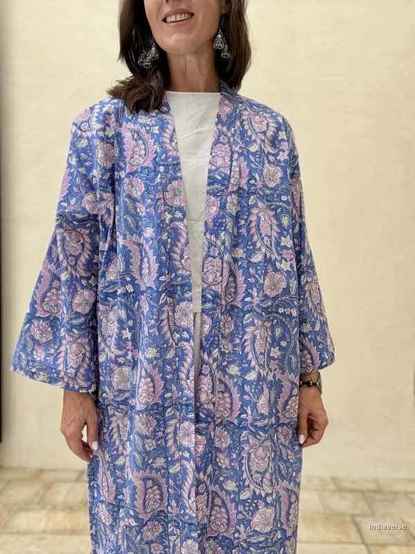 Woman wearing a blue floral patterned dress against a neutral background
