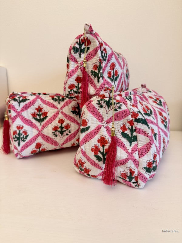 Three small fabric pouches with pink and red floral embroidery and tassel zipper pulls, arranged on a light beige surface against a cream background | Flower Candy