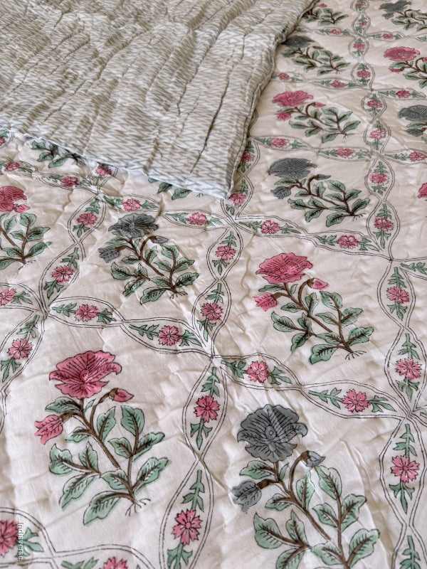 Close up of quilted blanket with red and blue flower design arrange in a geometric pattern