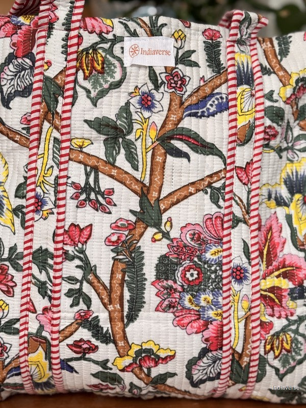 close up of the front of the quilted tote bag with floral jungle design and the label indiaverse attached