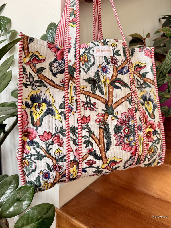quilted tote bag with floral design hanging from a wooden beam