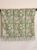 green cotton scarf with white floral pattern hanging from a wooden beam
