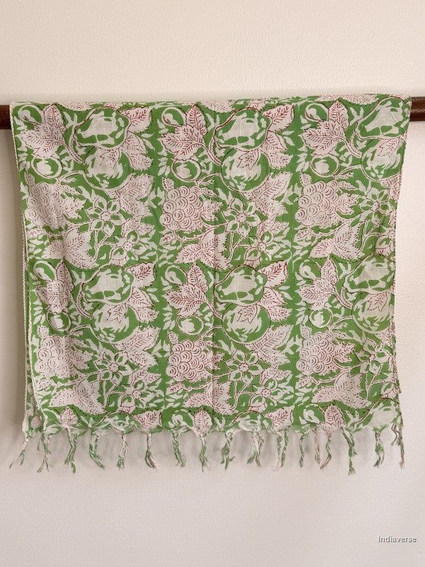 green cotton scarf with white floral pattern hanging from a wooden beam