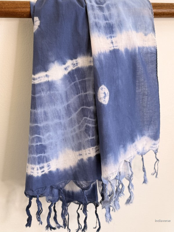 Indigo blue cotton scarf dyed with batik technique hanging from a wooden beam
