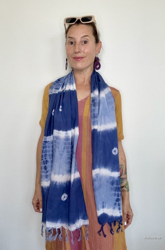 woman wearing a blue indigo cotton scarf standing in front of a white wall
