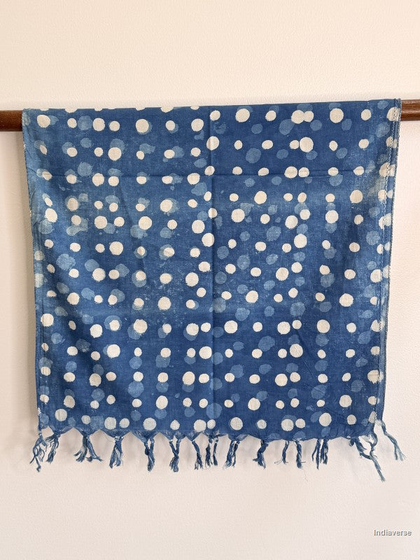cotton scarf in indigo blue with white dots hanging from a wooden beam