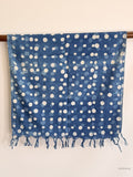 cotton scarf in indigo blue with white dots hanging from a wooden beam