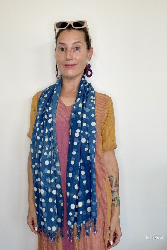 woman wearing an indigo blue cotton scarf standing in front of a white wall
