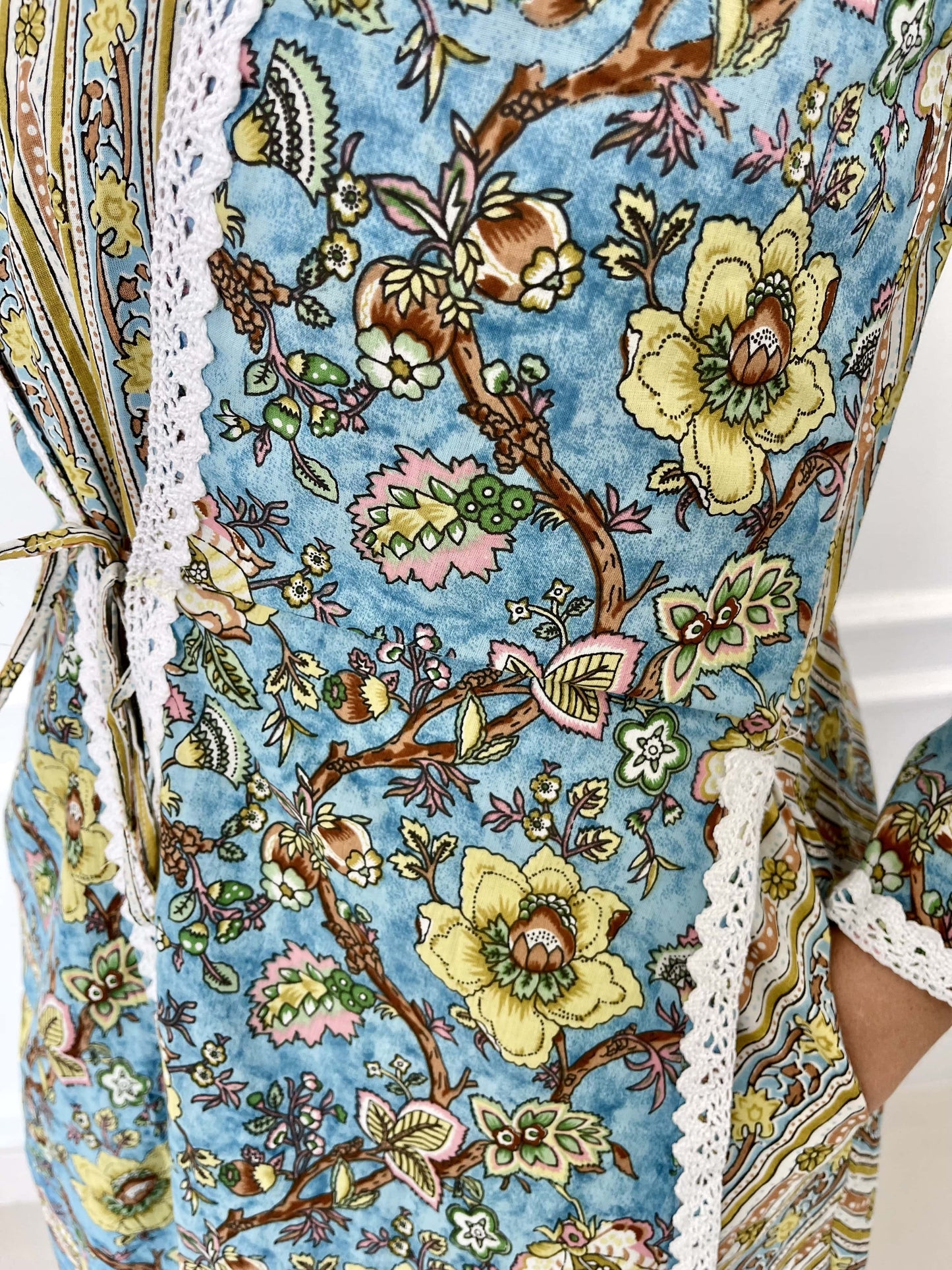 Long-cotton-dress-two-layered-look-with-white-lace-border-detail-and-blue-beige-yellow-floral-design-and-full-length-sleeves