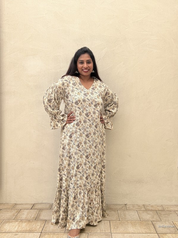 woman wearing a blue floral pattern dress in front of a beige wall