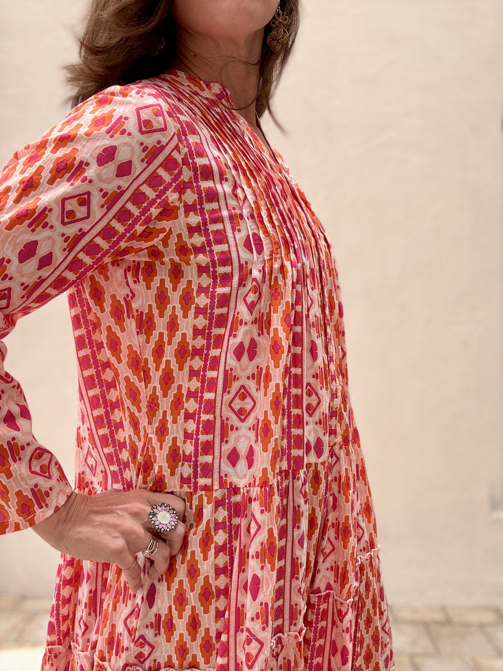 Woman wearing a red and white patterned dress against a neutral background