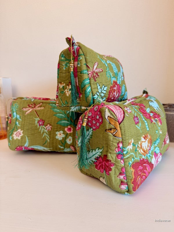Three quilted cosmetic pouches in a floral print fabric with green, pink, and teal tones, arranged on a light surface against a plain beige background | Magic Garden