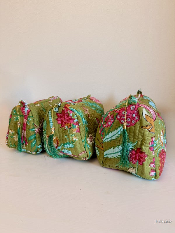 Three small quilted drawstring cosmetic pouches in a green floral kantha fabric, arranged on a plain beige surface | Magic Garden