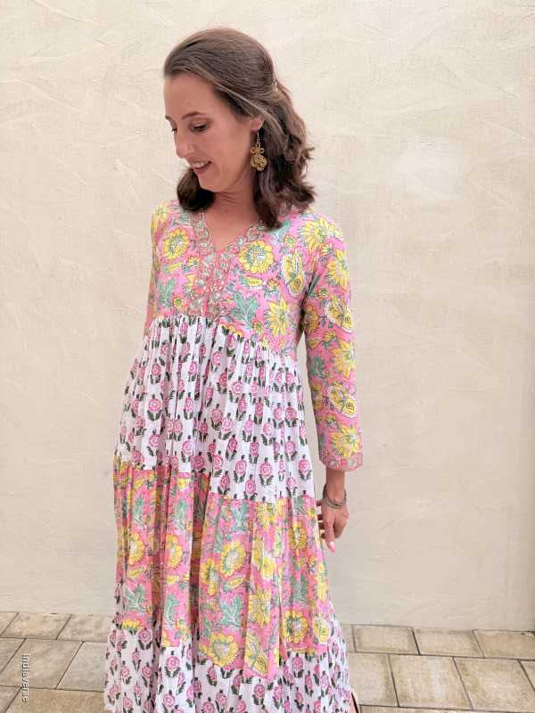 Woman wearing a colorful floral dress on a light background