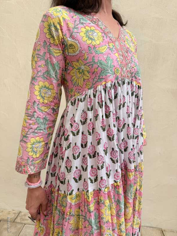 Person wearing a colorful floral dress on a beige couch