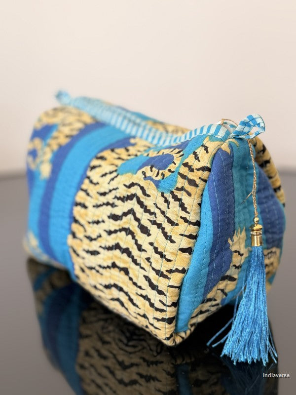 Blue and yellow patterned pouch with tassel on a neutral background